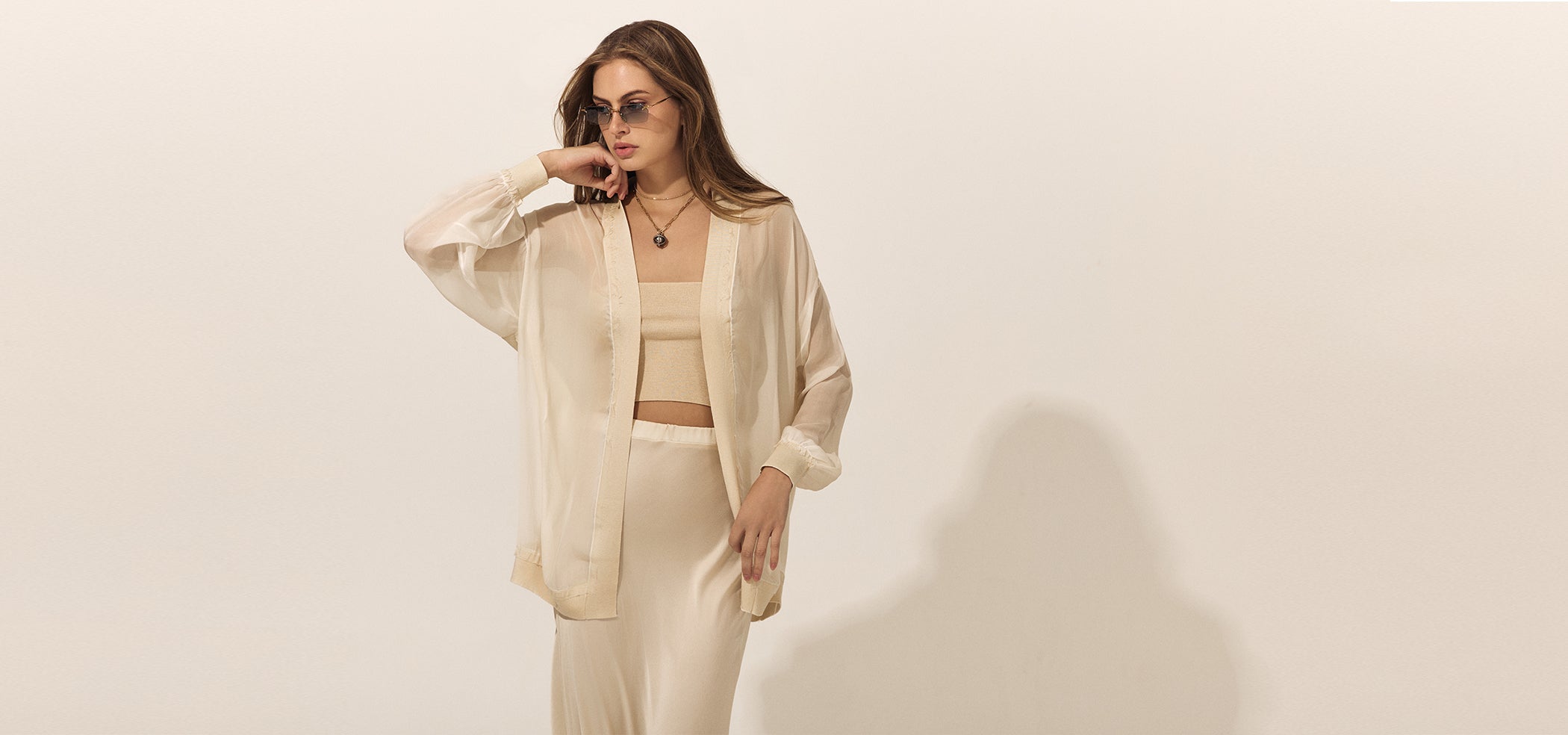 Woman wearing a beige outfit against a plain background